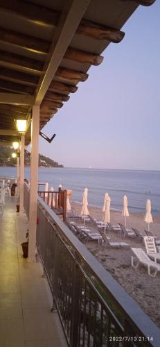 a beach with lounge chairs and the ocean at lemonishouse by the sea 2 in Nea Skioni