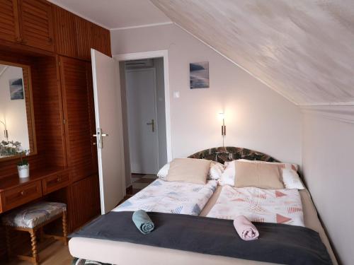 ein Schlafzimmer mit einem Bett und Hausschuhen darauf in der Unterkunft Aranyhal Vendégház in Sukoró