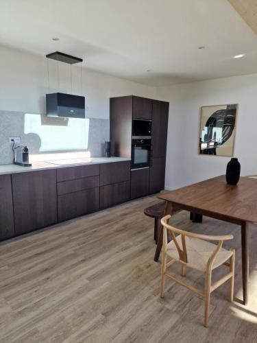 a kitchen with wooden cabinets and a wooden table at Duplex type chalet dans le Jura in Morbier