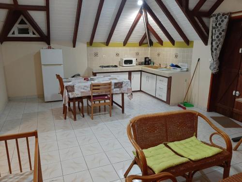 eine Küche mit einem Tisch und Stühlen im Zimmer in der Unterkunft Location appartement Idéal Vacances (avec une grande terrasse) in Petit-Canal