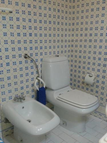 ein Badezimmer mit einem weißen WC und einem Waschbecken in der Unterkunft Quartos no centro de Torres Vedras in Torres Vedras