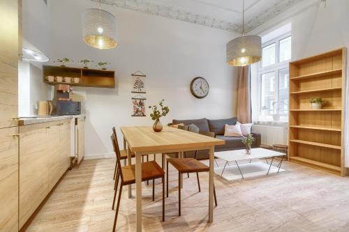 een keuken en een woonkamer met een houten tafel en stoelen bij Kamienica Centrum Apartament nr 3 in Szczecin