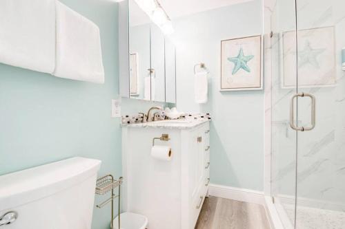 a white bathroom with a shower and a sink at OCEANIA... water front cottage retreat ~ in Cudjoe Key