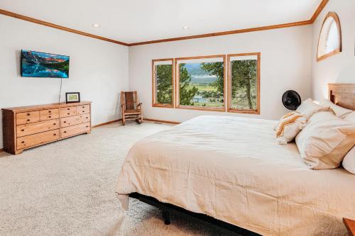 a bedroom with a bed and a dresser and windows at 310 Vista Drive in Ridgway