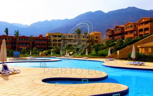 a swimming pool in a resort with mountains in the background at 2 Bedroom Ground floor Chalet with Terrace - Porto Sokhna - Families Only in Ain Sokhna