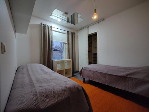 una camera d'albergo con due letti e una finestra di VillaSki a Rovaniemi