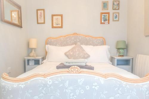 a bedroom with a large white bed with two tables at The Rear of the Plough,Everdon. in Daventry