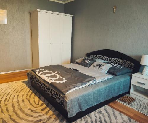 a bedroom with a bed and a white cabinet at Relax Apartman in Siófok