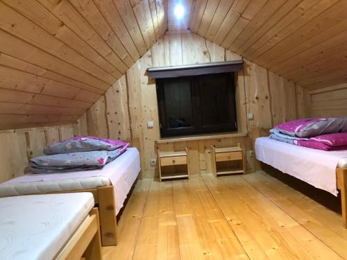 a room with two beds and a tv in a cabin at Pokoje u Adama Grajoka in Szczawnica