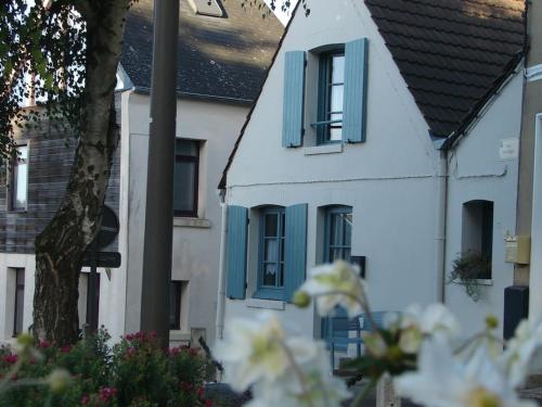 Biały dom z niebieskimi okiennicami w obiekcie AUTHENTIQUE MAISON DE PECHEUR ENTRE-TERRE & MER Avec Un POÊLE À BOIS A Disposition w mieście Saint-Valéry-sur-Somme