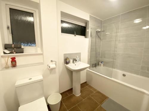 a bathroom with a toilet and a sink and a shower at ThePropertyFocus - Stylish Cosy Stay in Manchester