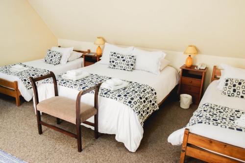 a room with two beds and two chairs in it at Hotel Rondó in Viña del Mar