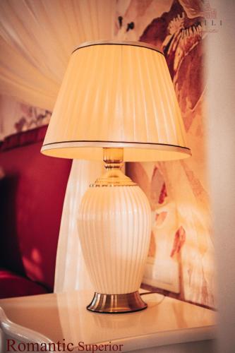 a white lamp sitting on top of a table at Vili Apartments in Oradea