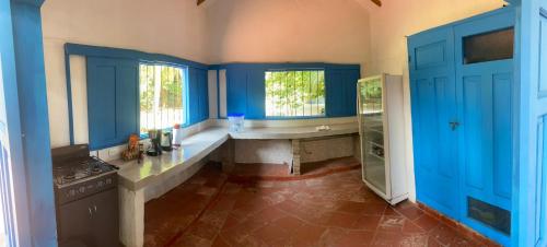 uma grande cozinha com armários azuis e um lavatório em Finca del Rio Palomino em Palomino