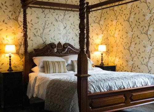 a bedroom with a canopy bed with floral wallpaper at Ye Olde Smugglers Inne in Alfriston