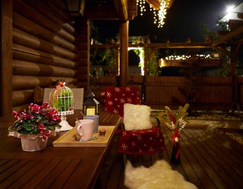 a wooden deck with a table with christmas decorations at Greenwood Rönkház in Gárdony
