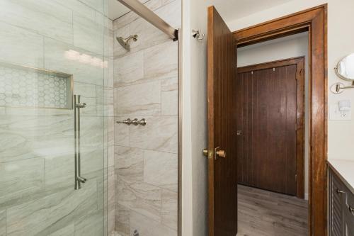 Un baño con ducha con puerta de cristal. en Tamarron Lodge Loft 316, en Durango