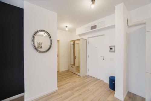 a hallway with white walls and a mirror at Duet Noir in Oradea