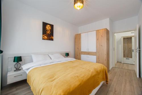 a bedroom with a large bed with a yellow blanket at Duet Noir in Oradea