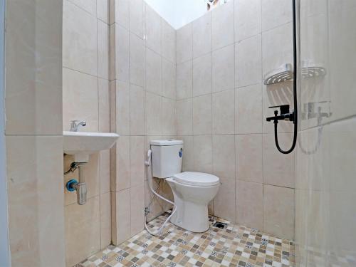 a bathroom with a toilet and a sink at OYO 92054 Gala Residence in Jambi