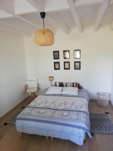 - une chambre avec un lit et une lampe pendant dans l'établissement Le Haut Séchoir, à Buzet-sur-Baïse