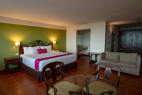 a hotel room with a bed and a couch at Gamma Merida El Castellano in Mérida