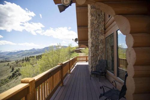 a porch of a log cabin with a view of the mountains at Bachelor Loop - 2310 in Creede