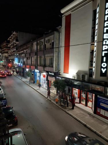 a city street at night with people walking on the sidewalk at October Luxury Apartments Studio in Ioannina