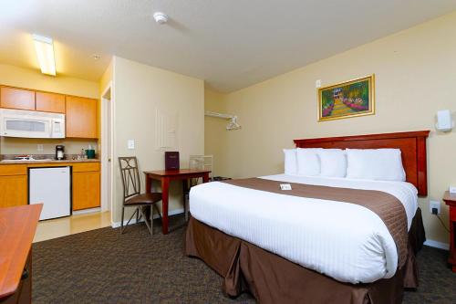 a hotel room with a large bed and a kitchen at Siegel Select Casa Grande in Casa Grande