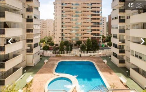 a swimming pool in the middle of two buildings at Apartamentos Novacala Benidorm in Cala de Finestrat
