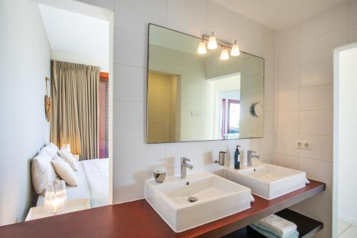 ein Badezimmer mit 2 Waschbecken und einem Spiegel in der Unterkunft Boca Gentil sea view apartment - Jan Thiel in Jan Thiel