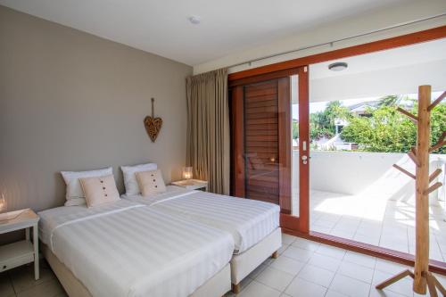 een slaapkamer met een wit bed en een balkon bij Boca Gentil sea view apartment - Jan Thiel in Jan Thiel