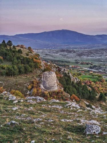 Blick auf einen Hügel mit Bäumen und Bergen in der Unterkunft Apartman City in Livno