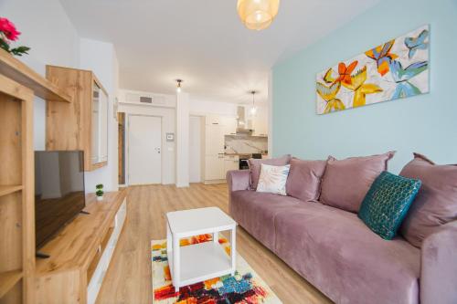 un salon avec un canapé violet et une table dans l'établissement Duet Blanc, à Oradea