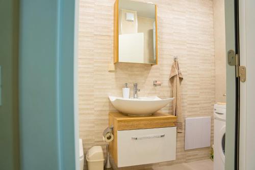 La salle de bains est pourvue d'un lavabo et d'un miroir. dans l'établissement Elite Business Residence, by Holiwork Stays, à Plovdiv