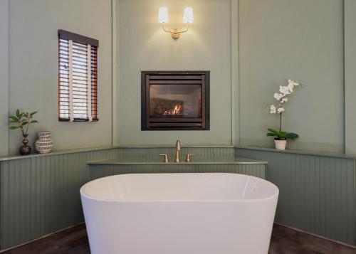 a bath tub in a bathroom with a fireplace at Outland Chalet & Suites Great Smoky Mountains in Whittier