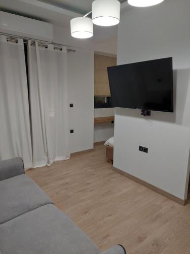 a living room with a couch and a flat screen tv at October Luxury Apartments Studio in Ioannina