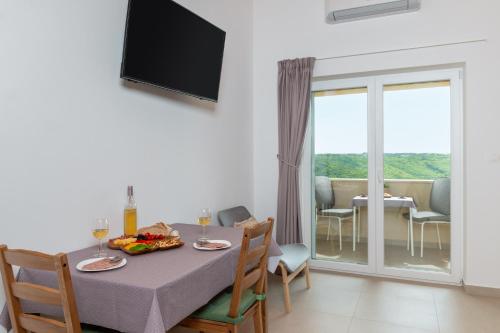 ein Esszimmer mit einem Tisch und einem Balkon in der Unterkunft Studio LAVANDA - Explore Istrian Riviera and Inland in Tinjan