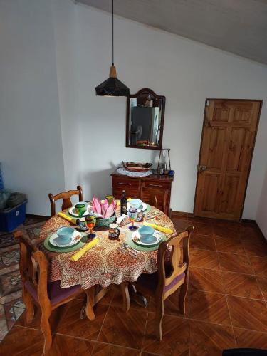 a dining room table with chairs and a table and a mirror at Private Mountain House With a Pool in Orotina