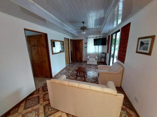 a living room with two couches and a television at Private Mountain House With a Pool in Orotina