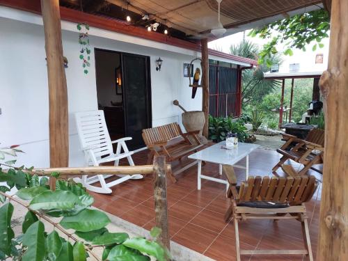 a patio with chairs and a table on a house at Private Mountain House With a Pool in Orotina