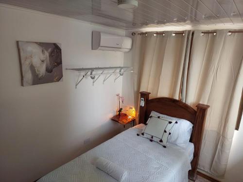 a small bedroom with a bed and a window at Private Mountain House With a Pool in Orotina