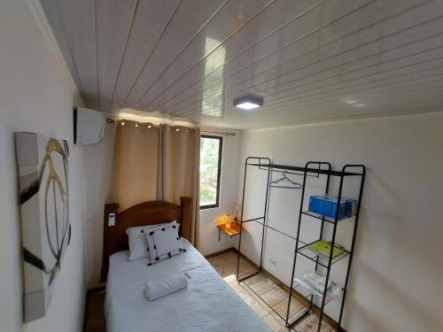 a small room with a bed and a shelf at Private Mountain House With a Pool in Orotina