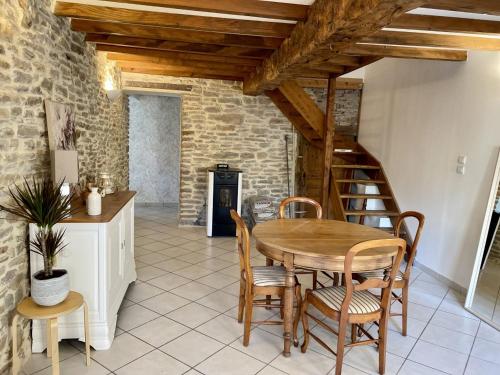 - une salle à manger avec une table et des chaises en bois dans l'établissement LES GLYCINES, à Hières-sur-Amby