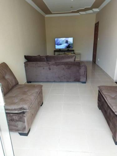 a living room with two couches and a flat screen tv at Apartamento de luxo com 2 quartos, sala com sacada, cozinha área de serviço e 1 banheiro social. in Ipatinga