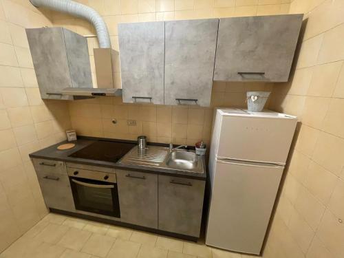 a small kitchen with a sink and a refrigerator at Lila House in Turin