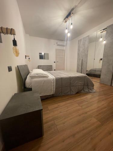 una camera con letto, tavolo e specchio di Prestige Appartament a Casale Monferrato