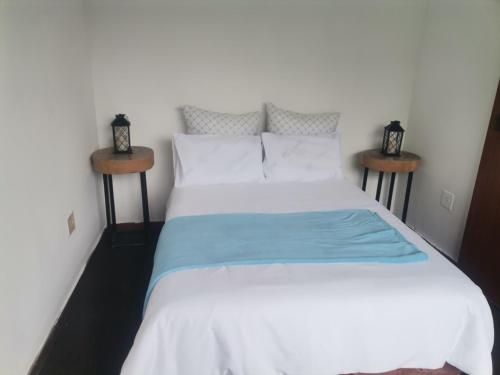 a bedroom with a white bed with two night stands at Luca's Place in Durban