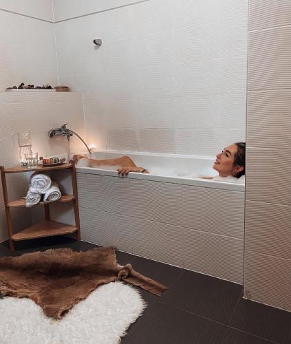 a woman laying in a bath tub in a bathroom at Chalet 12 Harrachov in Harrachov