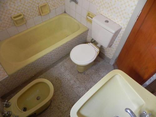 y baño con aseo, bañera y lavamanos. en ALQUILER DE CASA POR TEMPORADA en Necochea